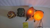 All four items front view: ceramic frog holder, green frog figurine, duck and turtle lamps lit