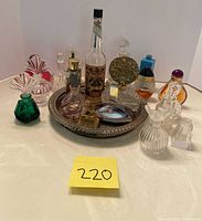 Group shot of all perfume bottles arranged on silver tray and surrounding