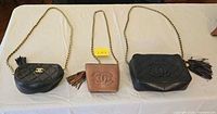 Overview of three Chanel bags laid flat showing size, color, quilting, CC logos, tassels, chain straps