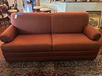 Front view of rust herringbone three-seat sofa