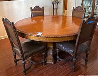 Overall view of round hardwood dining table and four matching chairs