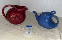 Overall view of burgundy McCoy pitcher and blue Hall teapot