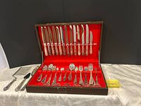 Open chest showing knives, forks, spoons and chest interior