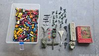 Overview of entire lot showing bin of cars, military toys, Hess truck, puzzle