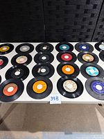 Tabletop view of 20 vinyl singles arrayed in four rows
