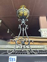 Full view showing complete lamp on wrought iron stand