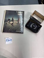 Camera next to book and open storage box