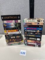 Two stacks of assorted VHS tapes on table