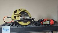 Circular saw and drill side by side on shelf