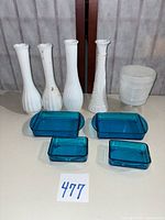 Group shot of four milk glass bud vases, milk glass bowl, and four blue glass trays