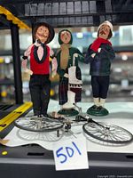 overview of three Byers Choice caroler figures and metal bicycle