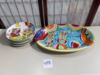 Stack of five plates alongside large oval platter