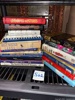 Front view of entire lot of stacked hardcover and paperback books