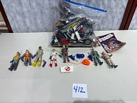 Overview of seven Ghostbusters figures, Lego bag, comic