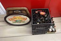 Sierra Nevada sign leaning on wall beside crate of bottles and cans