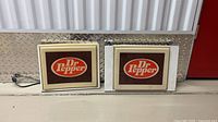 Two Dr Pepper illuminated signs side by side showing overall condition and cords