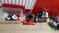 Overall lot showing tote of ornaments, tree stand, Noma light boxes, loose lights, snowflake