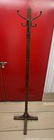 Full view of oak coat rack showing post and base