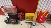 Overall lot with paddle, life jacket, Ski-Doo bag, plaid items, stove, stool and propane