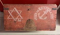 Top of red wooden crate showing white anchor logo and Star of David device