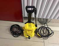 Full view of pressure washer with hose, spray gun and cord