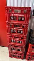 Stack of red National Dry crates filled with clear glass bottles