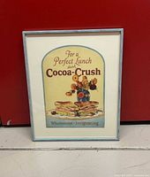 Framed Cocoa-Crush advertisement in full view