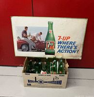 Front view of sign and bottles in box