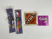 Front view shows both wristwatches in sleeve packaging, Orange Crush framed label, and Grape Crush paper label