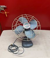 Front angled view of Electrohome Model 1065 fan showing four blades, wire cage, base and cord