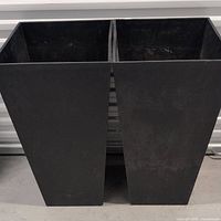 Pair of large black square tapering planters side by side showing front view
