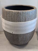Front and side view of large textured garden plant pot showing ribbed and rough stone-like finishes