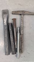 Photo showing the hammer, two chisels, and two punches laid out on the floor displaying condition and wear.