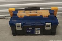 Front view of Mastercraft Maximum toolbox showing yellow compartment lid, silver latches, black handle, and branding label.