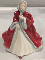 Front view of the Royal Doulton Rachel figurine showing facial detail, red cloak with gray fur trim, and cream gown.
