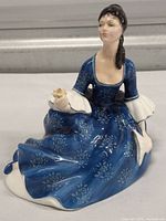 Front and left-side view of the Royal Doulton Rosalind figurine showing detailed floral blue dress and white lace trimmed sleeves.