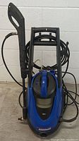 Front view of blue Simoniz power washer with handle and coiled hose attached