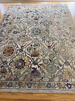Full view of the large Gertmenian area rug laid flat showing floral and medallion pattern and border detail.