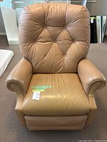 Front view of tan leather La-Z-Boy recliner showing button tufted backrest, padded armrests, and seat cushion.