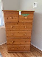 Front view of solid pine wood tall boy dresser with six drawers and round wooden knobs.
