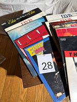 Stack of Elvis Presley records showing various covers, lot tag visible