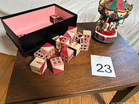 Top view of wooden blocks outside black box and carousel figurine on table