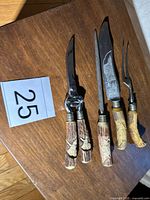 Full view of all four carving utensils lined up on tabletop