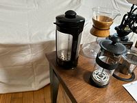 Overall view showing French press, Chemex carafe, small frother, manual grinder, stainless filter