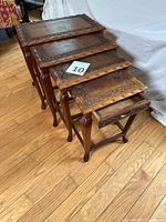 All four nesting tables pulled out to show graduated sizes and carved tops