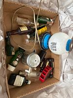 Overview of lot in box showing lamp, coffee pot, bottles, red caddy