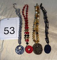 Group view of four stone pendants with necklaces