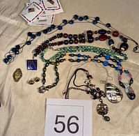 Full lot overview showing necklaces, pendants, brooch, pin and carded pieces