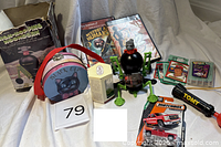 Group shot showing all items including Hoomdorn box and toy, PS2 games, Matchbox car, baseball cards, tin