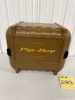 Closed brown plastic Pip-Boy storage case front view